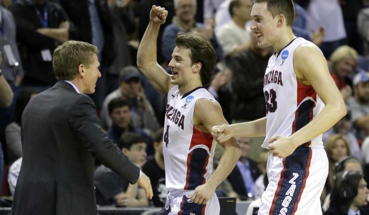 Gonzaga Coach Mark Few celebrates with Kevin Pangos, center, and Kyle Wiltjer late in the second half of their victory over Iowa on Sunday.
