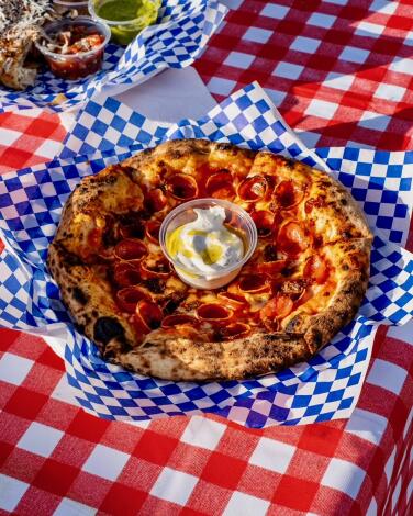 A pizza on a picnic table