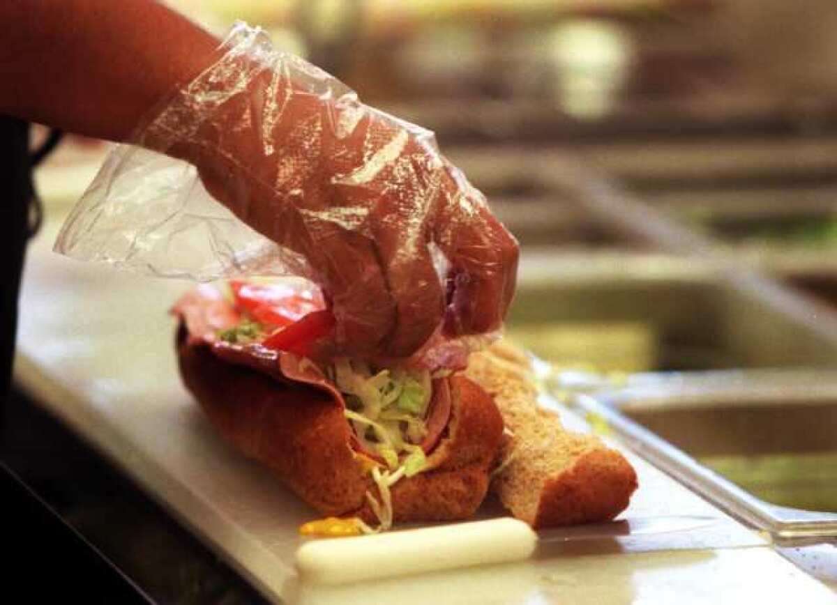 A Subway employee makes a sandwich. The chain was ranked one of the top five companies for best customer experience.