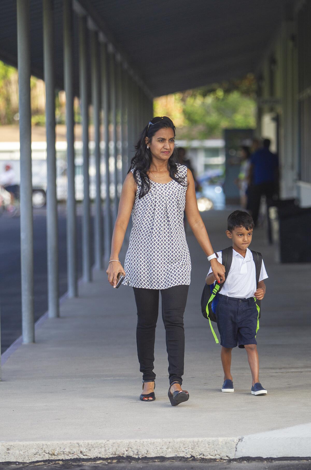 Sujana Setty walks Arjun Selamkoti, 4, to his first day of transitional kindergarten on opening day of the new International School for Science and Culture in Costa Mesa on Tuesday.