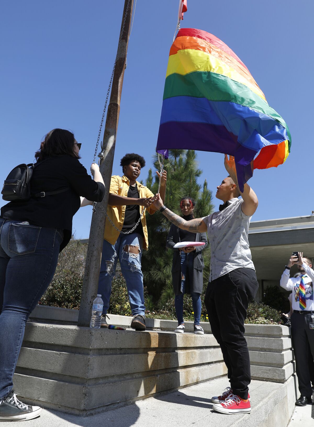 San Diego Unified School District Friday raised a pride flag and Trans flag at district headquarters for the first time in its history. Students Jay Sieber (left), Savion Morgan Cooper (center), Samsara Drapiza (background) and Ebonee Weathers, an SDUSD program manager (right) raised the LGBTQIA and Trans flags.