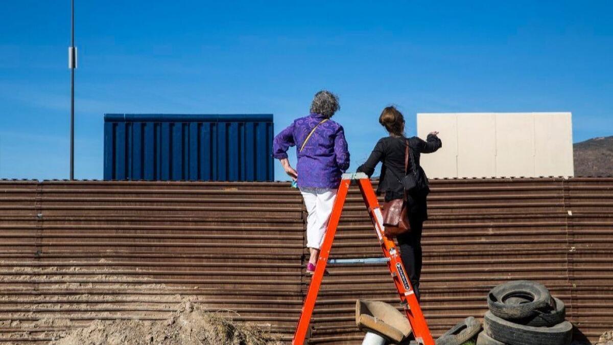 Deborah Joyce of Laguna Beach, left, talks with Nina Magnusdottir during a tour last month to view the border wall prototypes from the Tijuana side. President Trump is scheduled to see the prototypes on Tuesday.