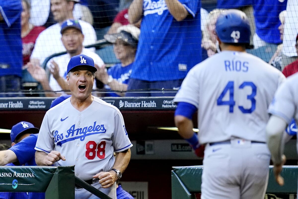 Dodgers bench coach Bob Geren reacts as Dodgers' Edwin Ríos returns to the dugout.