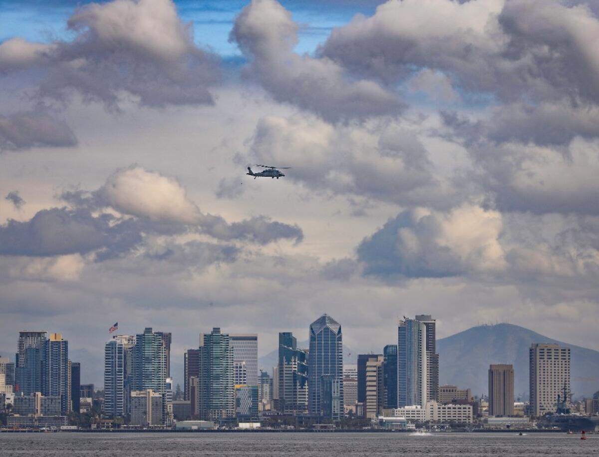A Navy helicopter passes by downtown San Diego in 2019.