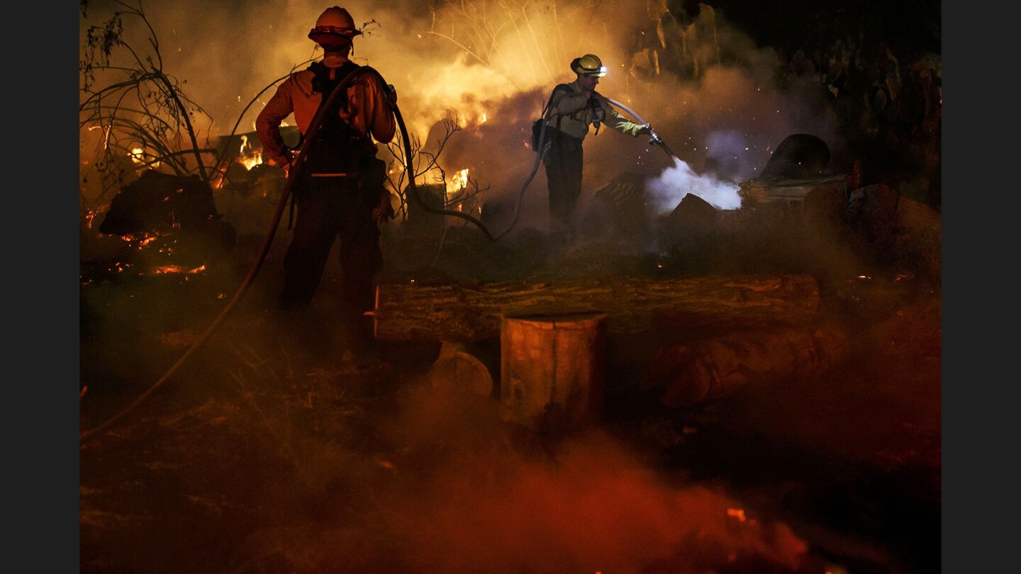 Firefighters battle Thursday to protect the resort city of Ojai from encroaching flames.