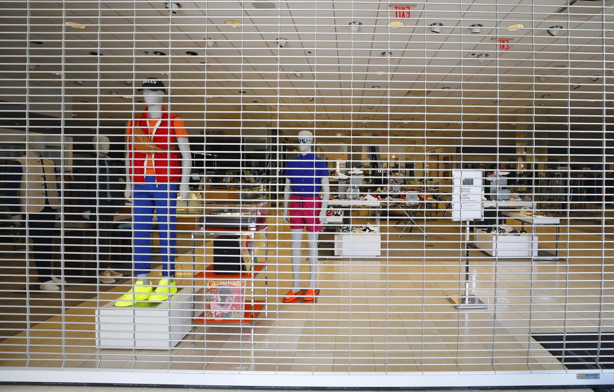 Mannequins stand behind a security gate at Neiman Marcus in Fashion Valley.