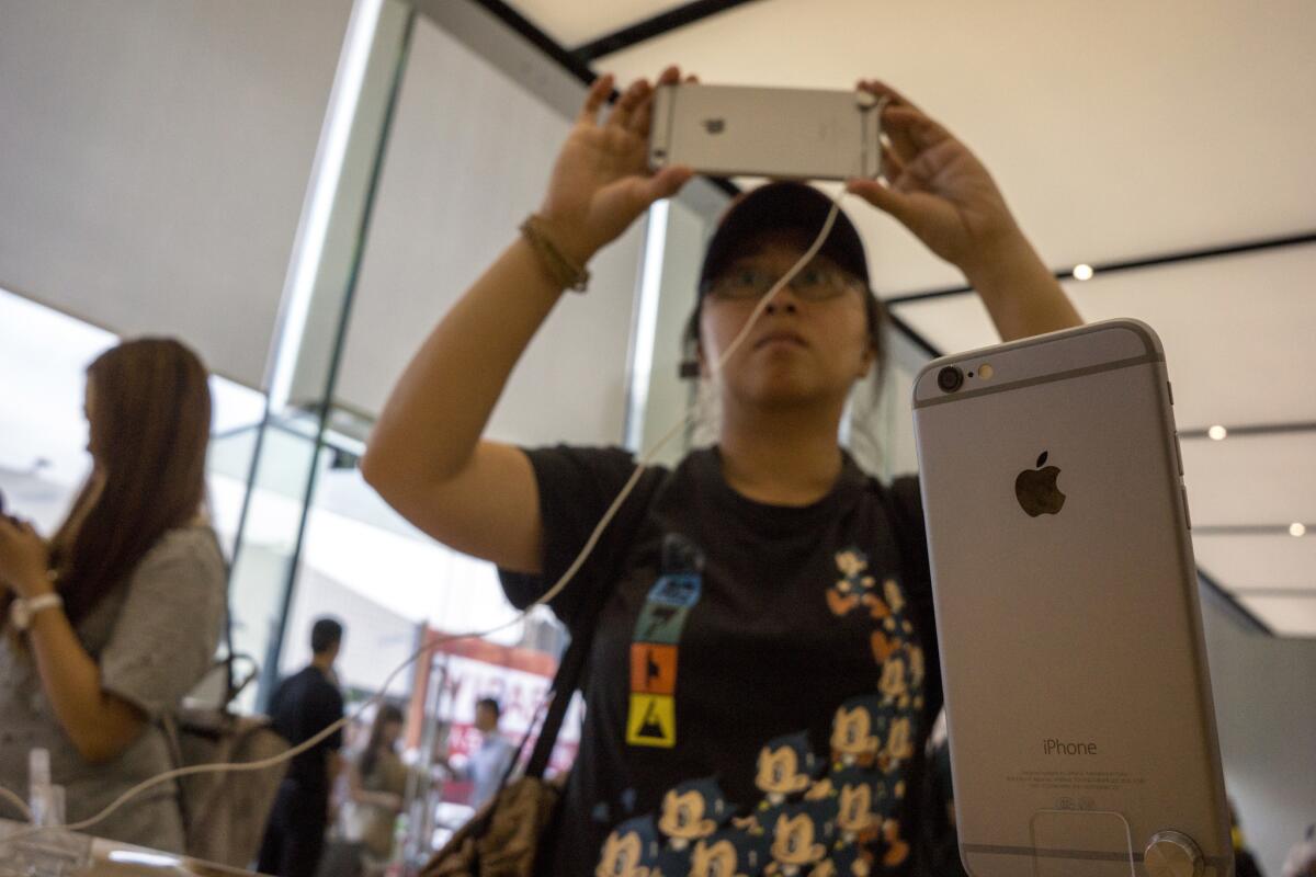 Chinese customers try out iPhones at the Apple store in Hangzhou, China.