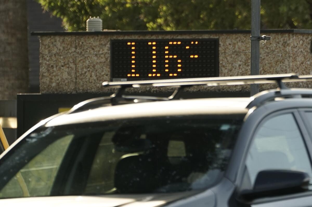 A vehicle passes a digital sign that reads 116 degrees