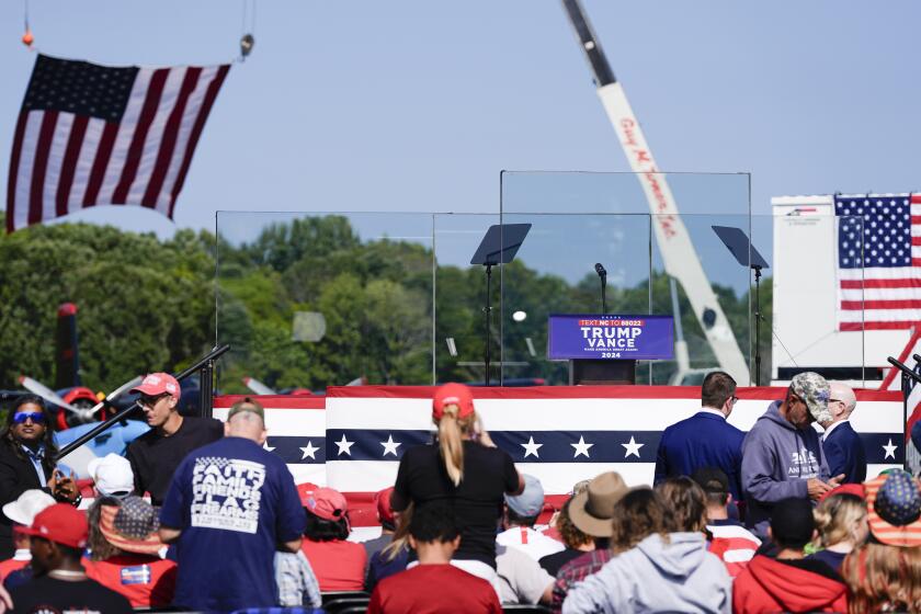 An outdoor stage is set encased with bulletproof glass as supporters arrive to hear Republican presidential nominee former President Donald Trump speak at a rally, Wednesday, Aug. 21, 2024, in Asheboro, N.C. Trump is holding his first outdoor rally since narrowly surviving an attempted assassination when a a gunman opened fire in Pennsylvania last month. (AP Photo/Julia Nikhinson)