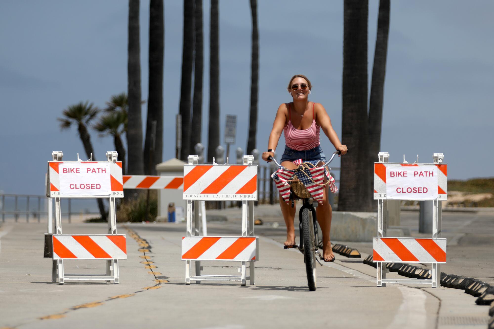 A bicyclist rides along the closed bike path in Manhattan Beach.