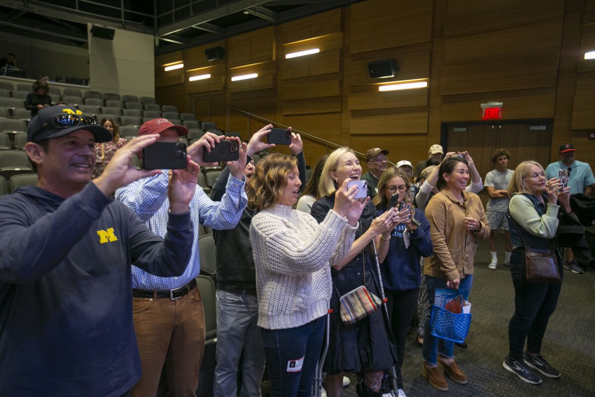 Family members take pictures of student-athletes during the Corona del Mar signing day on Monday.