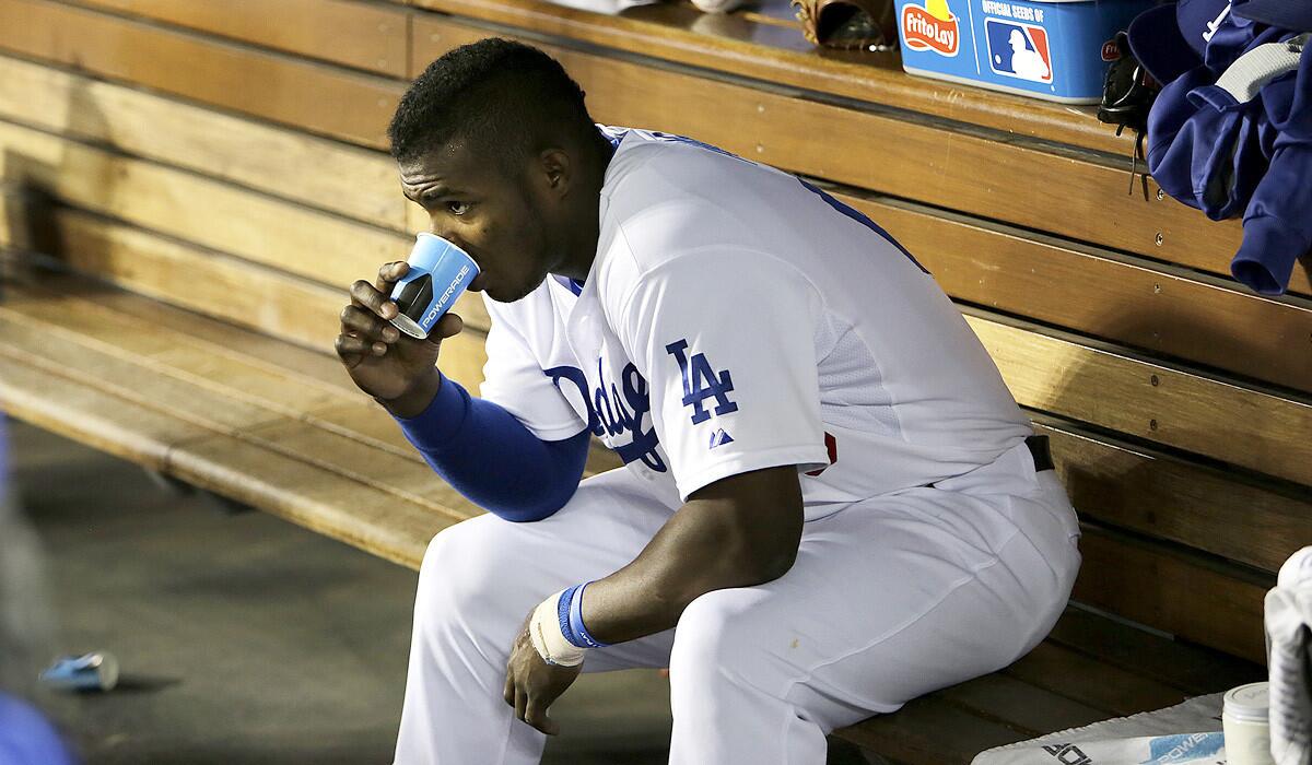 Dodgers outfielder Yasiel Puig sits in the dugout late in the game after striking out twice with runners on base against the San Diego Padres on Wednesday night.