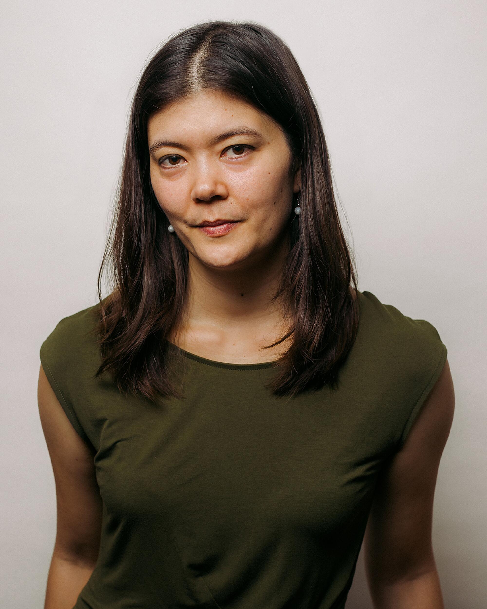 Kayla Min Andrews, a woman in a green short-sleeved shirt.