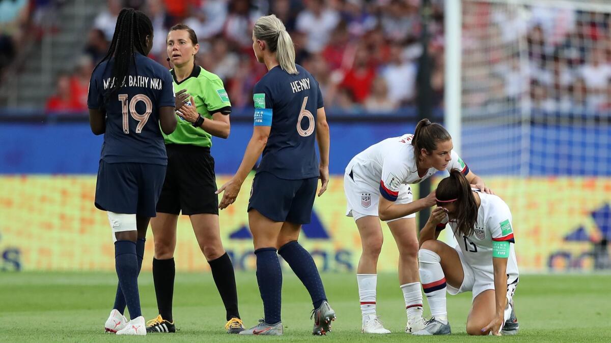 Referee Maryna Striletska talks to Griedge Mbock Bathy of France following a foul on Alex Morgan of the U.S.