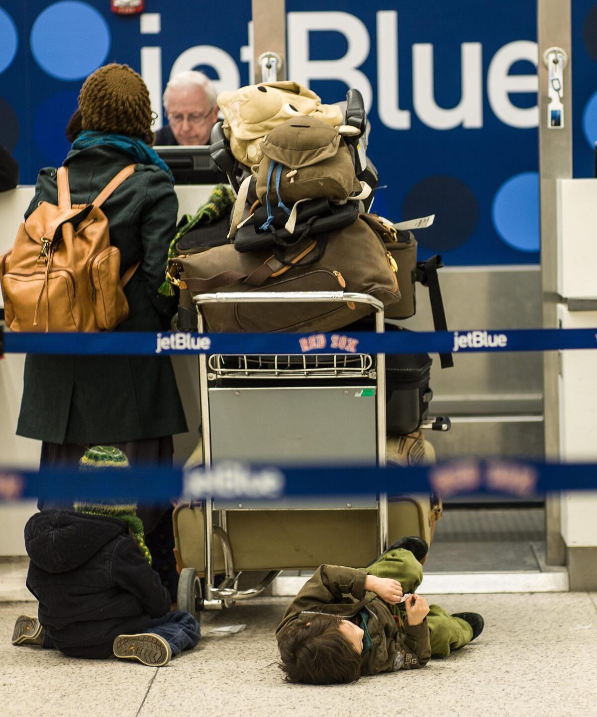 Travelers at Logan International Airport in Boston last month try to rebook their canceled JetBlue flights.