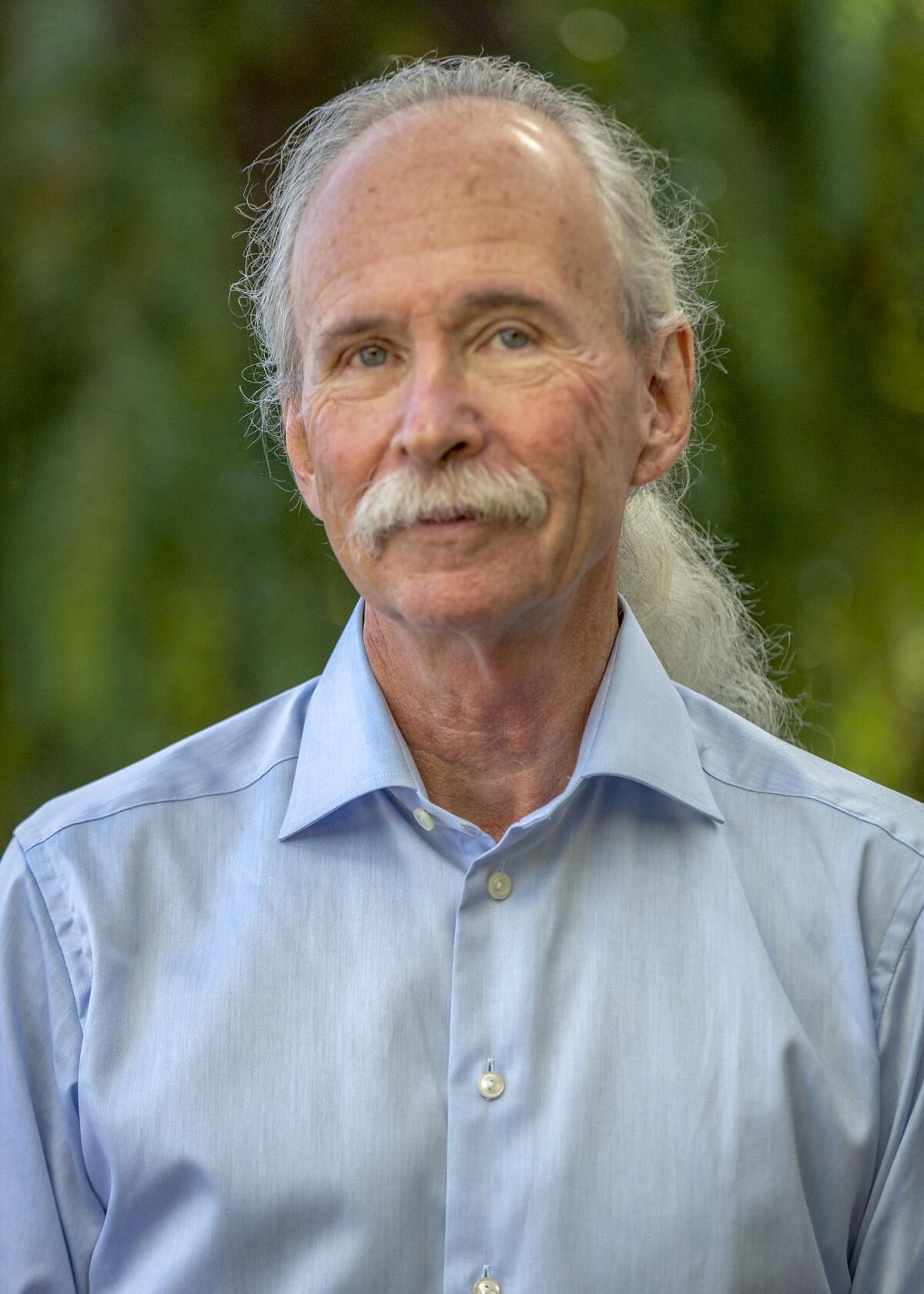 A man with long white hair and a mustache.