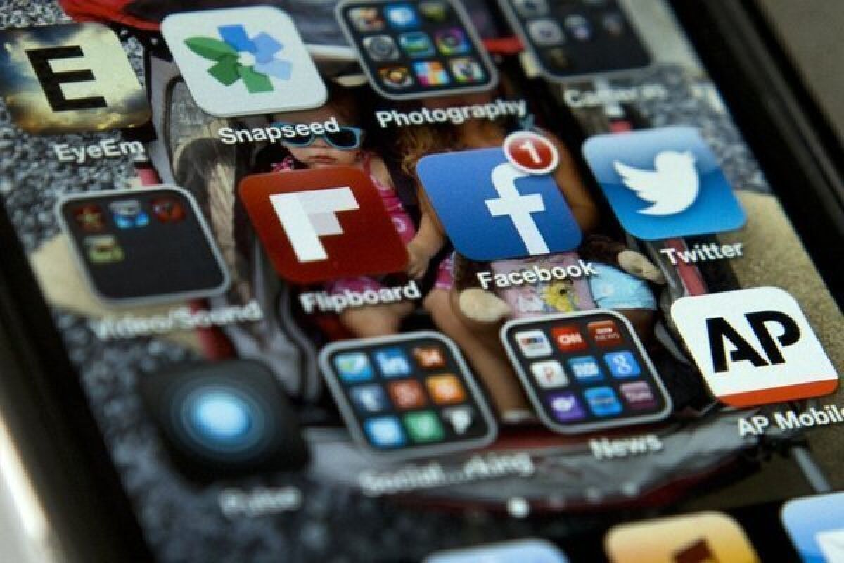 An iPhone showing the Twitter and Facebook apps, among others.
