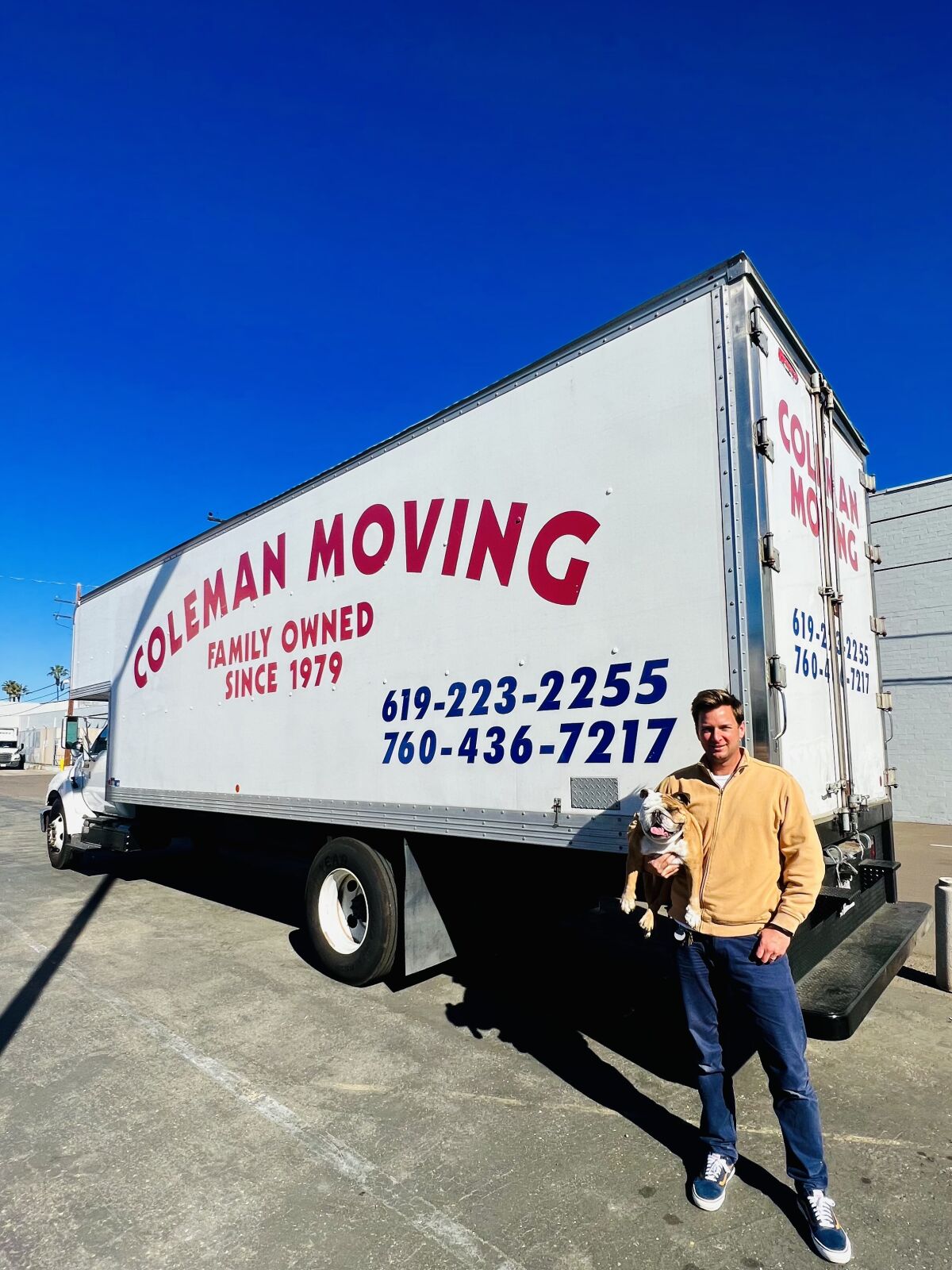Matt Coleman, vice president of Coleman Moving Systems Inc., holds Betty the bulldog in an undated photo.