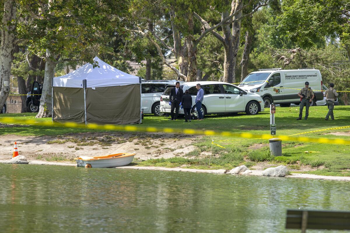 Sheriff's and OC Parks' personnel on Friday survey North Lake at Mile Square Park in Fountain Valley, where a body was found.