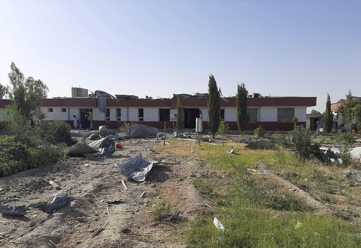 A low building is surrounded by some rubble.