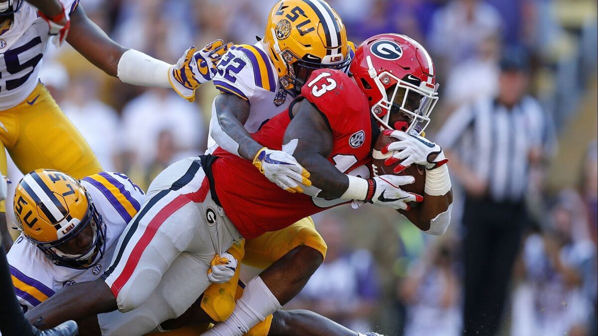 Georgia's Elijah Holyfield scores a touchdown as Louisiana State's Kristian Fulton defends during the second half on Oct. 13.