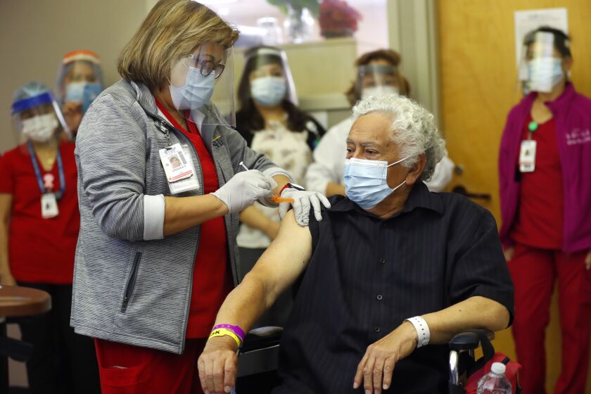 CHULA VISTA, CA - DECEMBER 21: Carlos Alegre, 72, a long-term care resident of Birch Patrick Skilled Nursing Facility at Sharp Chula Vista Medical Center receives a COVID-19 vaccine shot from LVN Virginia Vivar on Monday, Dec. 21, 2020 in Chula Vista, CA. Alegre is among the first patients to get the vaccine in the county. (K.C. Alfred / The San Diego Union-Tribune)