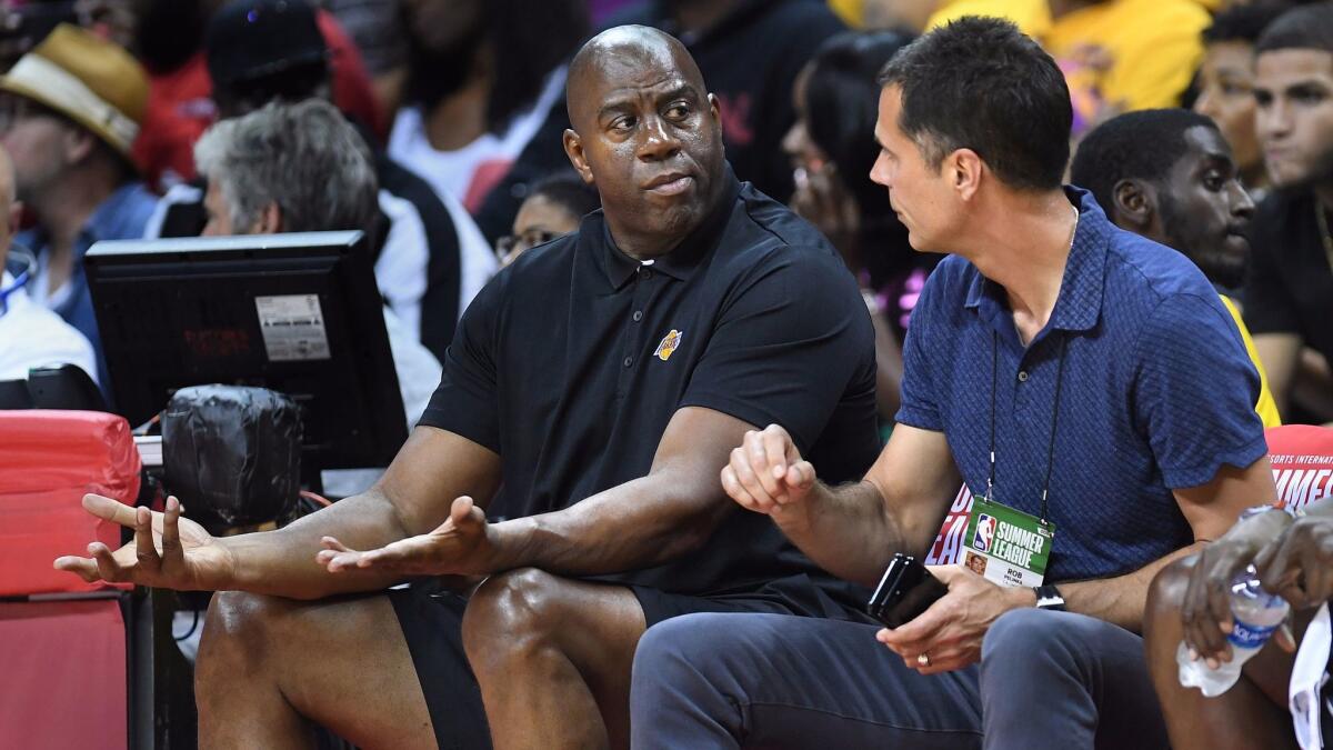 Magic Johnson and Rob Pelinka chat during a Las Vegas Summer League game in 2017.