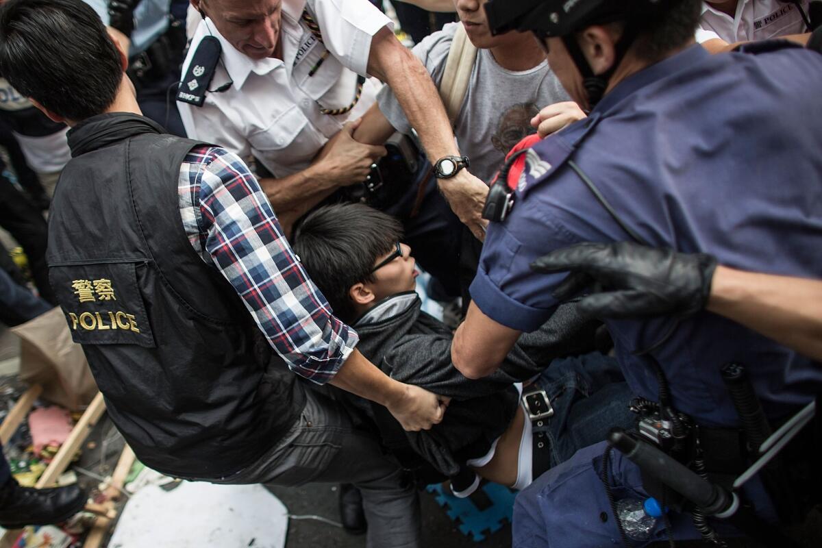 Police officers arrest Joshua Wong, a prominent student leader, in the city's Mong Kok district on Nov. 25.