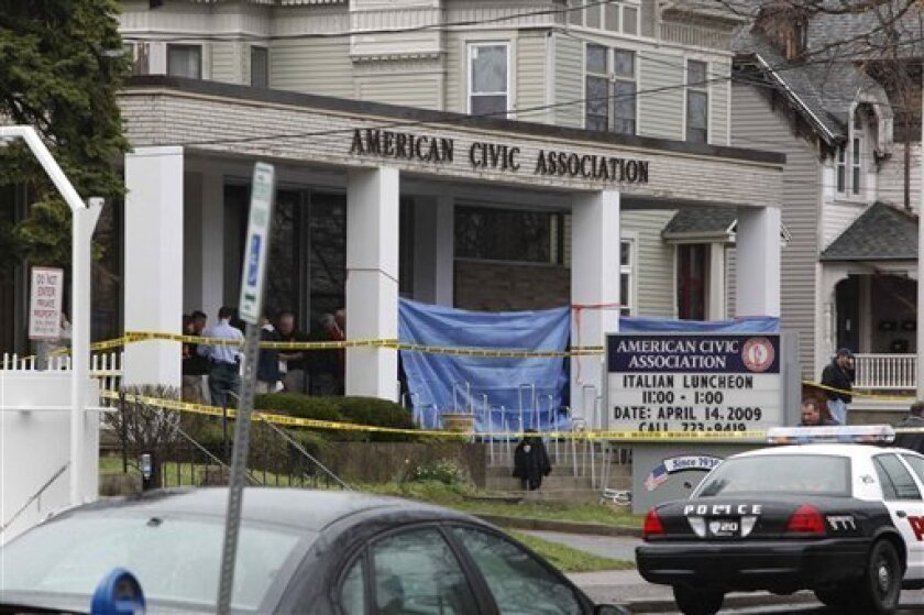 Officials work at the American Civic Association in Binghamton, N.Y. where a gunman opened fire Friday, April 3, 2009. A gunman barricaded the back door of a community center with his car and then opened fire on a room full of immigrants taking a citizenship class Friday, killing 13 people before apparently committing suicide, officials said. (AP Photo/Matt Rourke)