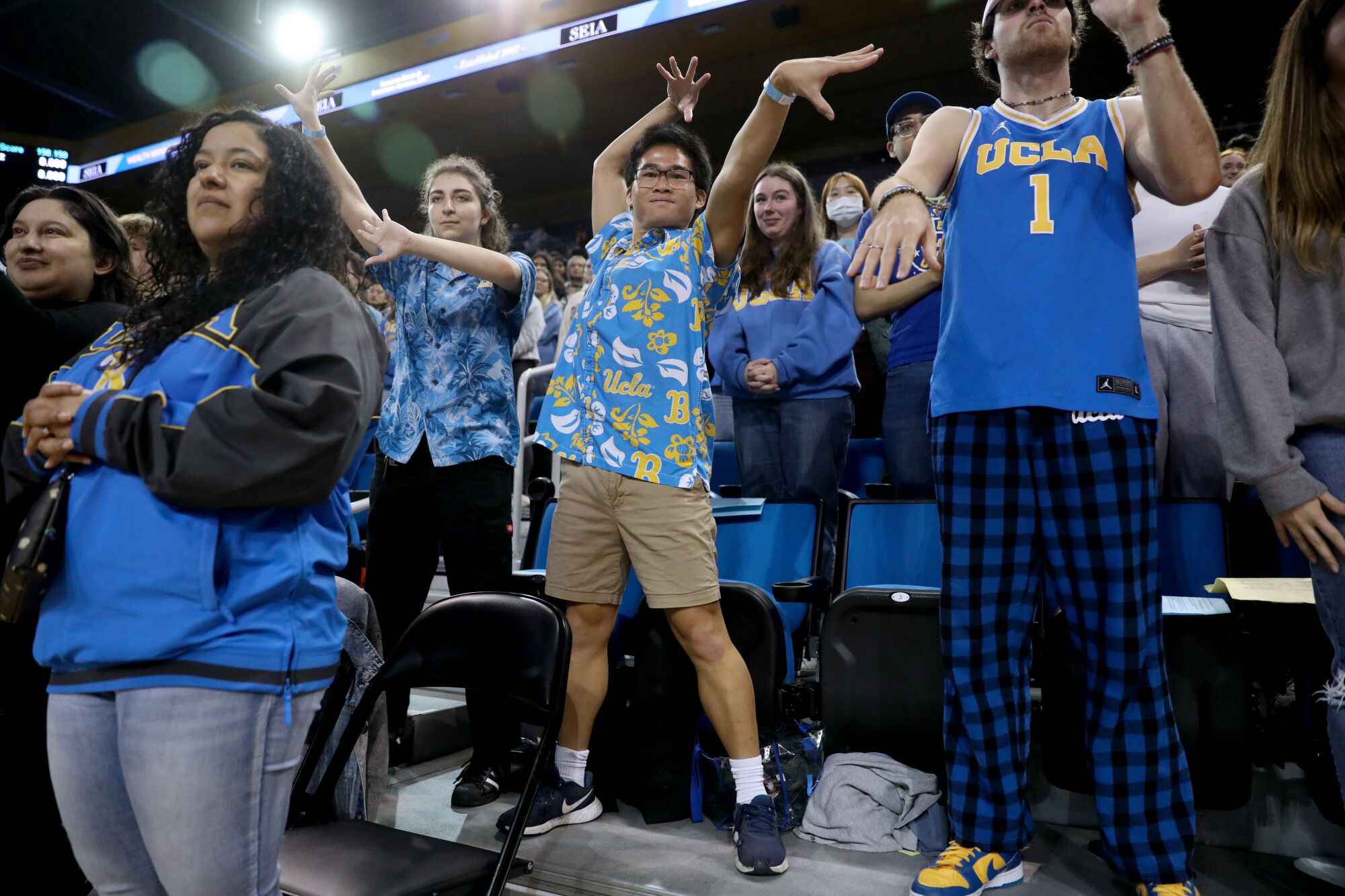 UCLA superfan Josh Lim and friend Laura DeFalco mimic a Bruins gymnast's floor exercise routine.