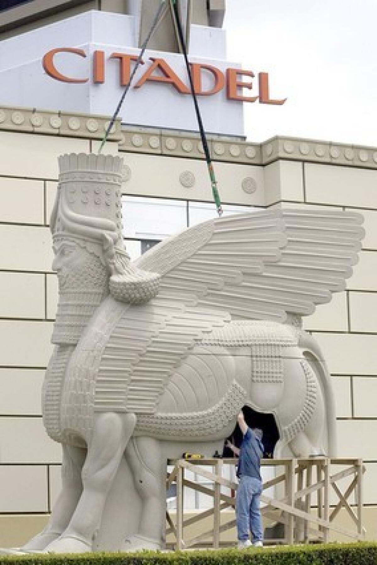 A lamassu (shown here during a nonholiday time) is an ancient design of a creature with animal legs, bird wings and the face of a man. The statue is at the Citadel Outlets in Commerce.
