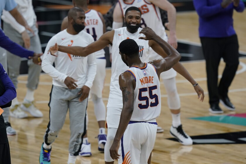 Phoenix Suns guard E'Twaun Moore (55) celebrates with teammates after his winning score against the San Antonio Spurs during the second half of an NBA basketball game against the San Antonio Spurs in San Antonio, Sunday, May 16, 2021. (AP Photo/Eric Gay)