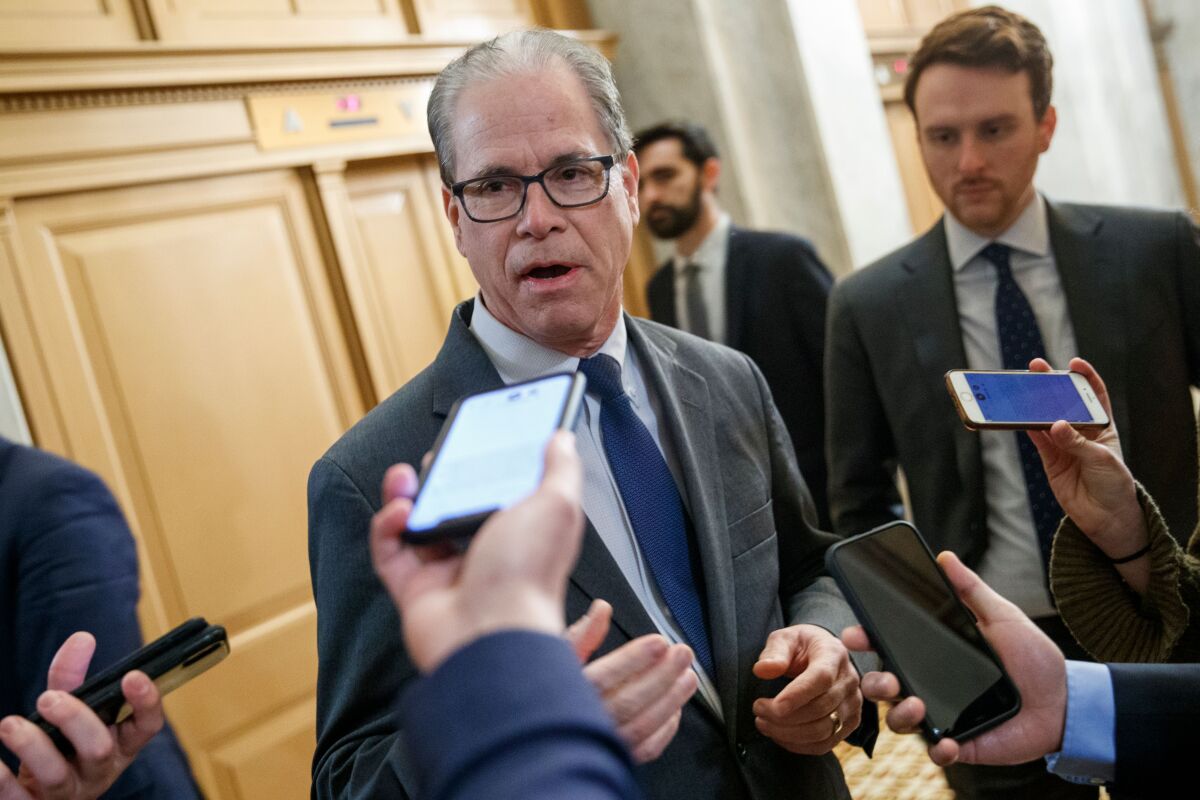 Mike Braun surrounded by reporters