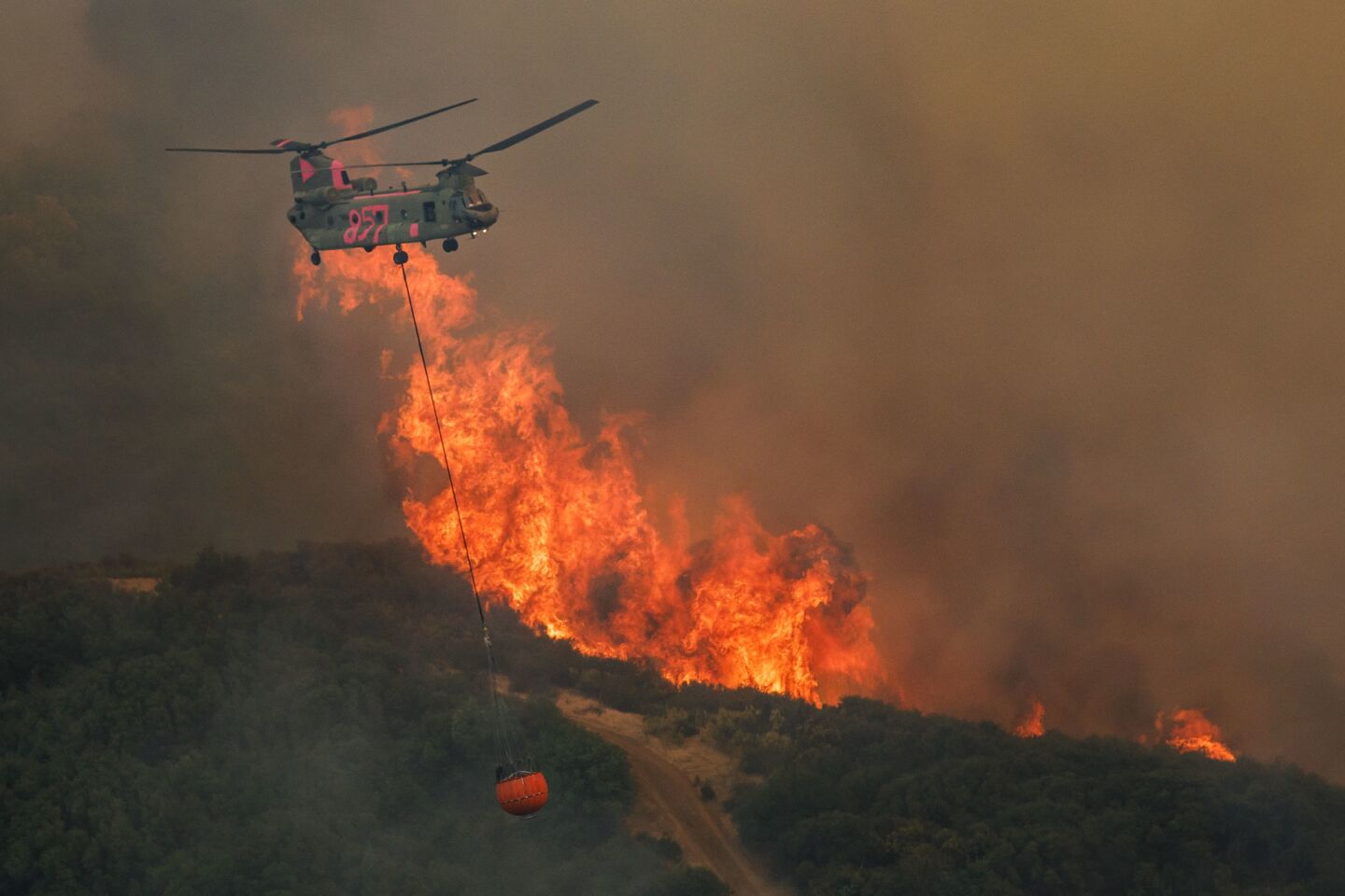 A helicopter makes a water drop near the raging Mendocino complex fires west of Lakeport, Calif., on July 31.