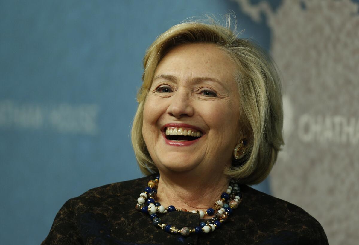 Former Secretary of State Hillary Rodham Clinton laughs as she arrives for an event at Chatham House in London.