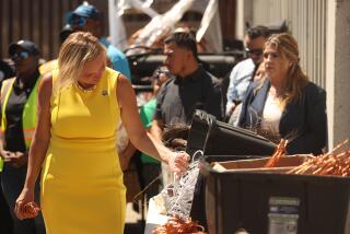 Los Angeles, CA - July 30: 11th District Los Angeles City Council Member Traci Park looks through copper as 14th District Los Angeles City Council Member Kevin de Leon speaks on a recent copper wire bust on Tuesday, July 30, 2024 in Los Angeles, CA. (Michael Blackshire / Los Angeles Times)