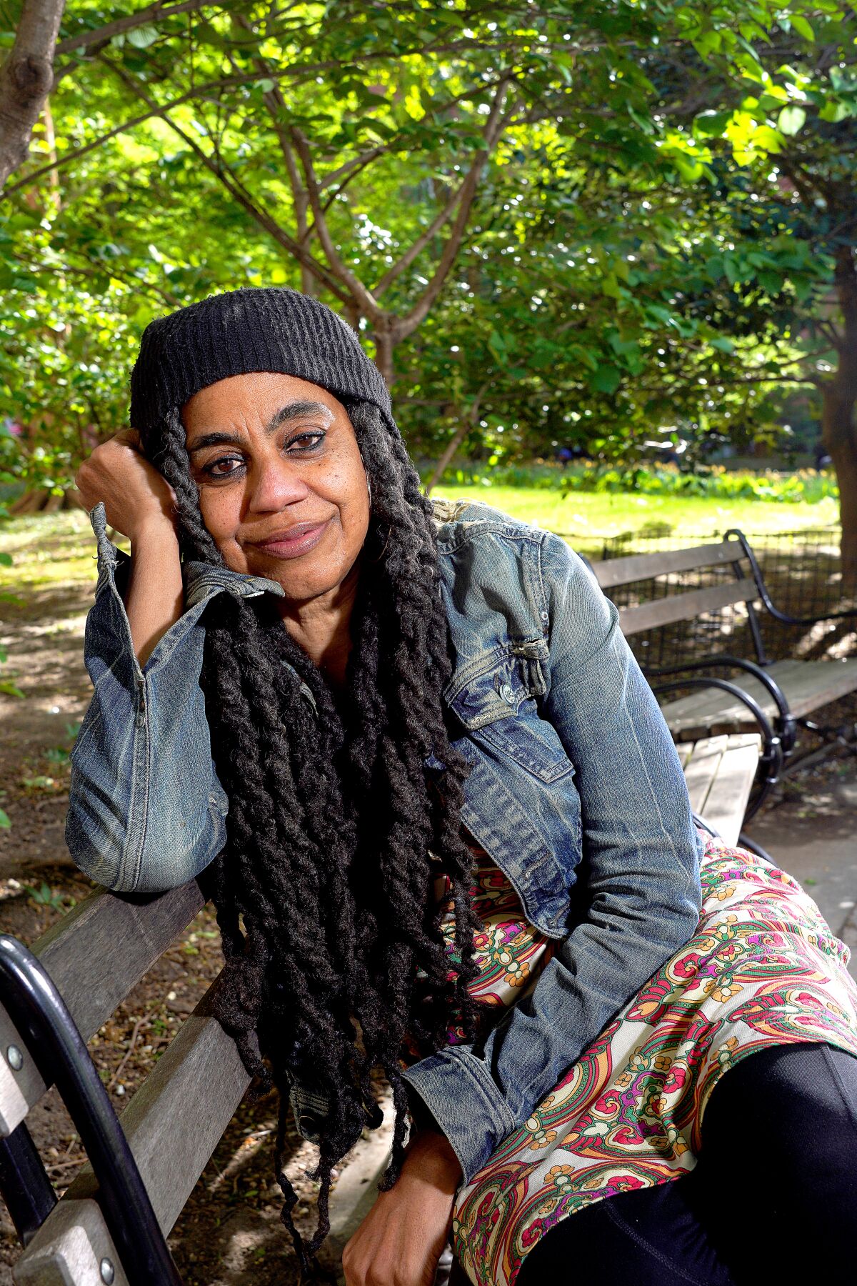 Suzan-Lori Parks, showrunner of "Genius: Aretha," sits on a bench with trees behind her. 