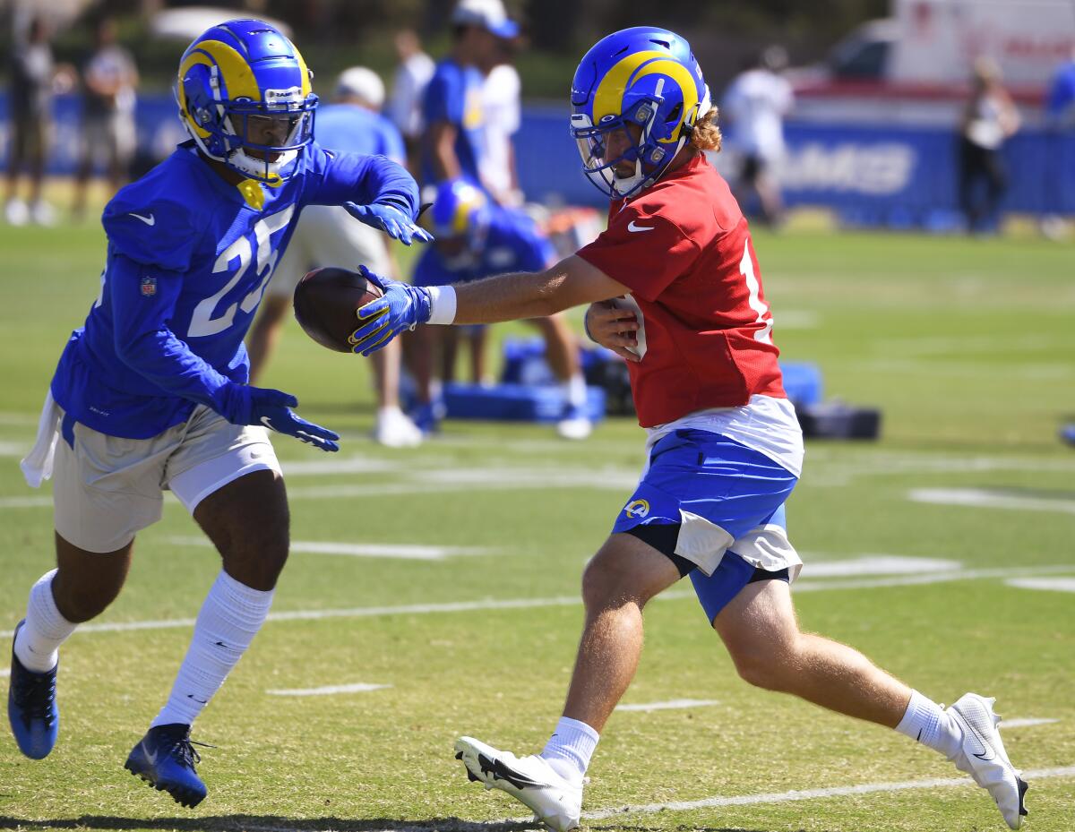 Rams running back Xavier Jones takes a handoff from Devlin Hodges during training camp.