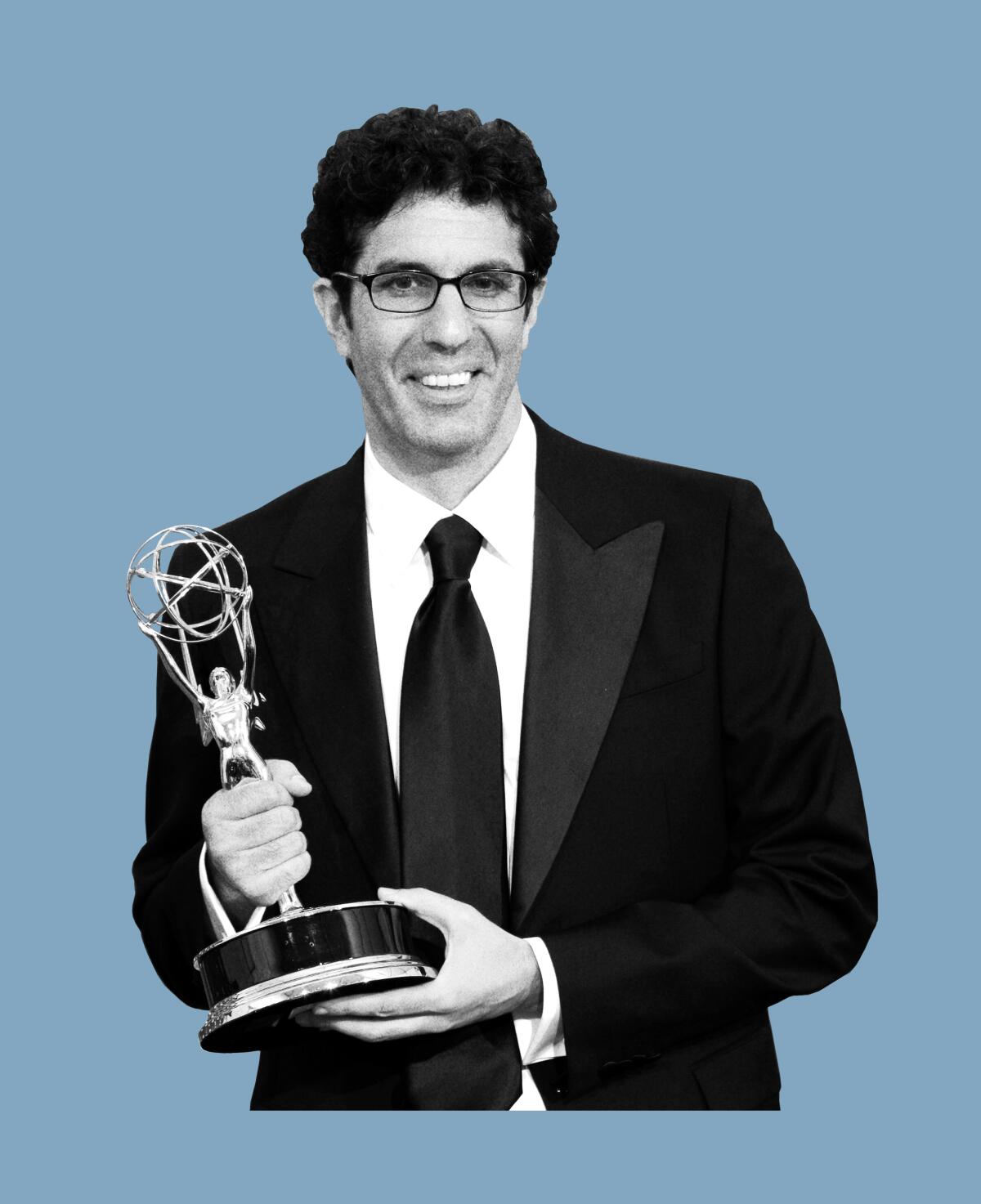 Jeffrey Blitz, in a black suit and tie, holds his Emmy with both hands.