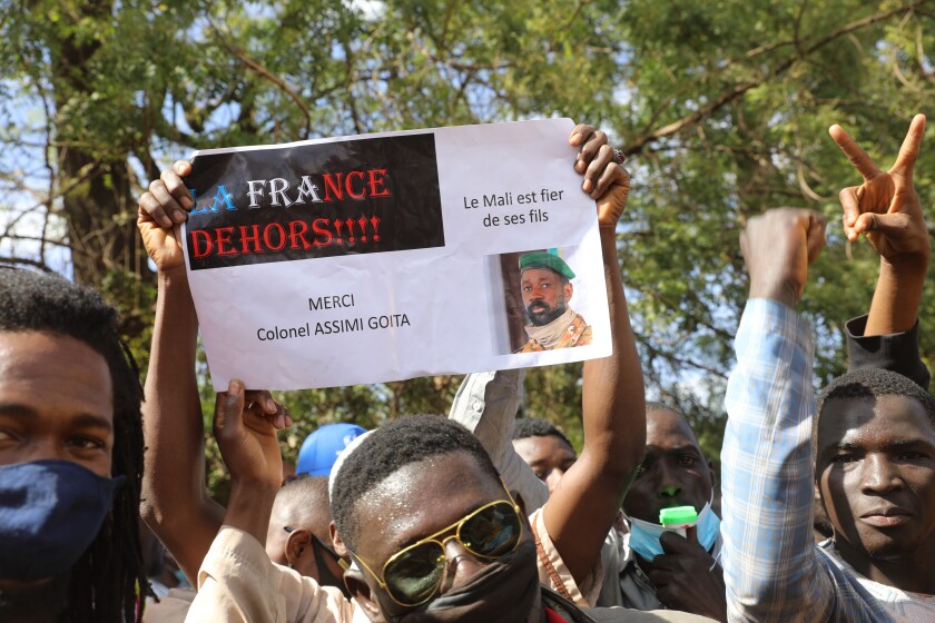 Thousands join a government-sponsored rally in Mali's capital Bamako Friday Jan. 14, 2021 to protest new regional economic sanctions and growing pressure from former coloniser France, after Mali's military ruler pushed back promised elections by four years. Sign reads: "France Out" , "Mali is proud of its sons" and "Thank you Colonel Assimi Goita." (AP Photo/Harandane Dicko)