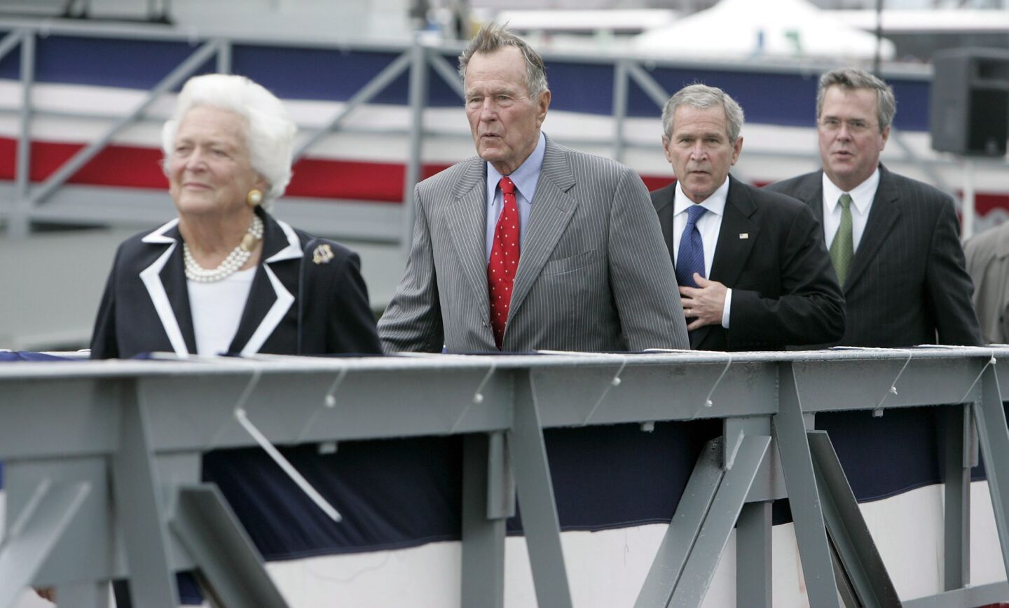 Barbara Bush walks in front of George H.W. Bush, George W. Bush and Jeb Bush at a christening ceremony for the U.S. Navy's new aircraft carrier the George H.W. Bush at Newport News, Va., on Oct. 7, 2006.