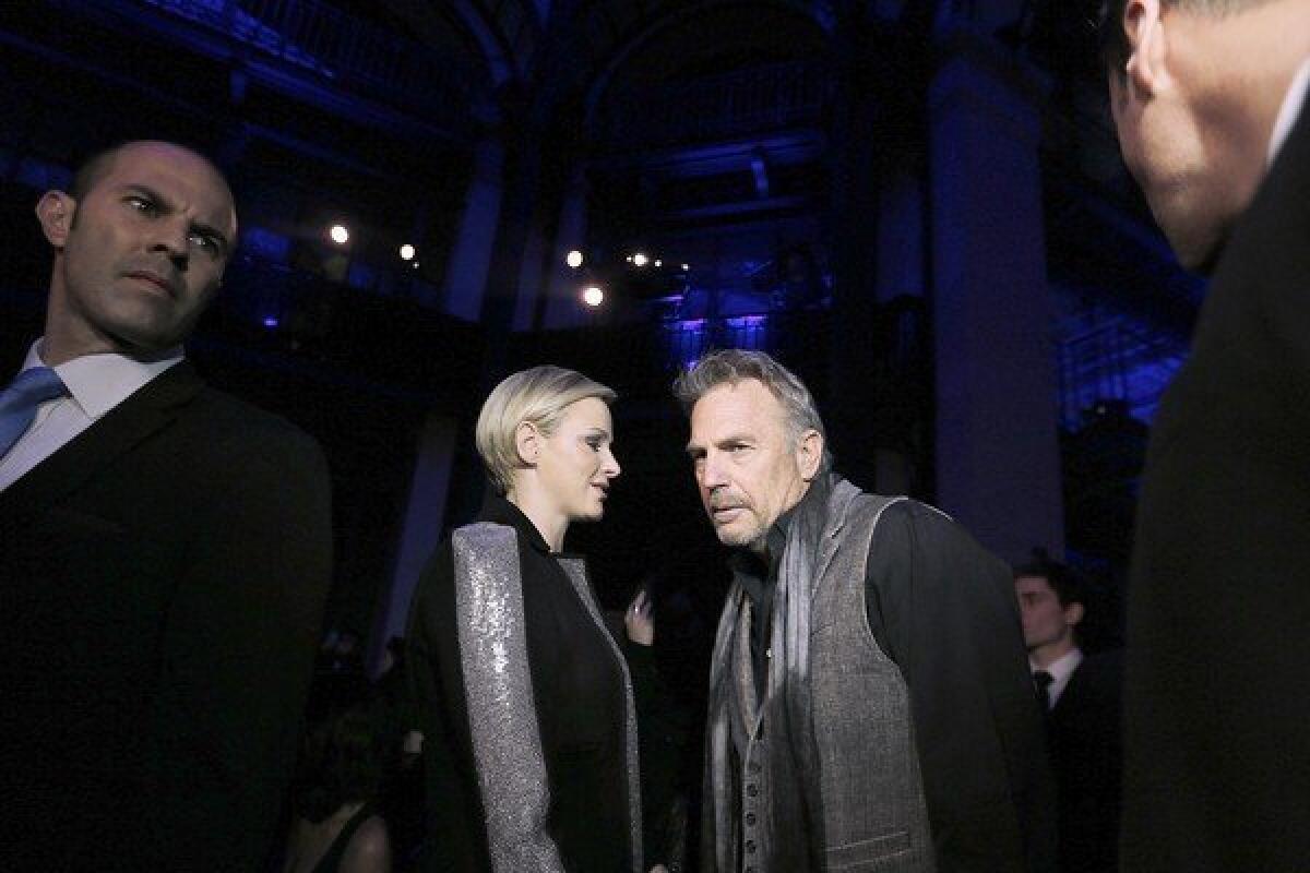 Princess Charlene speaks with actor Kevin Costner before the Haute Couture Spring-Summer 2013 Versace collection show on Sunday in Paris.