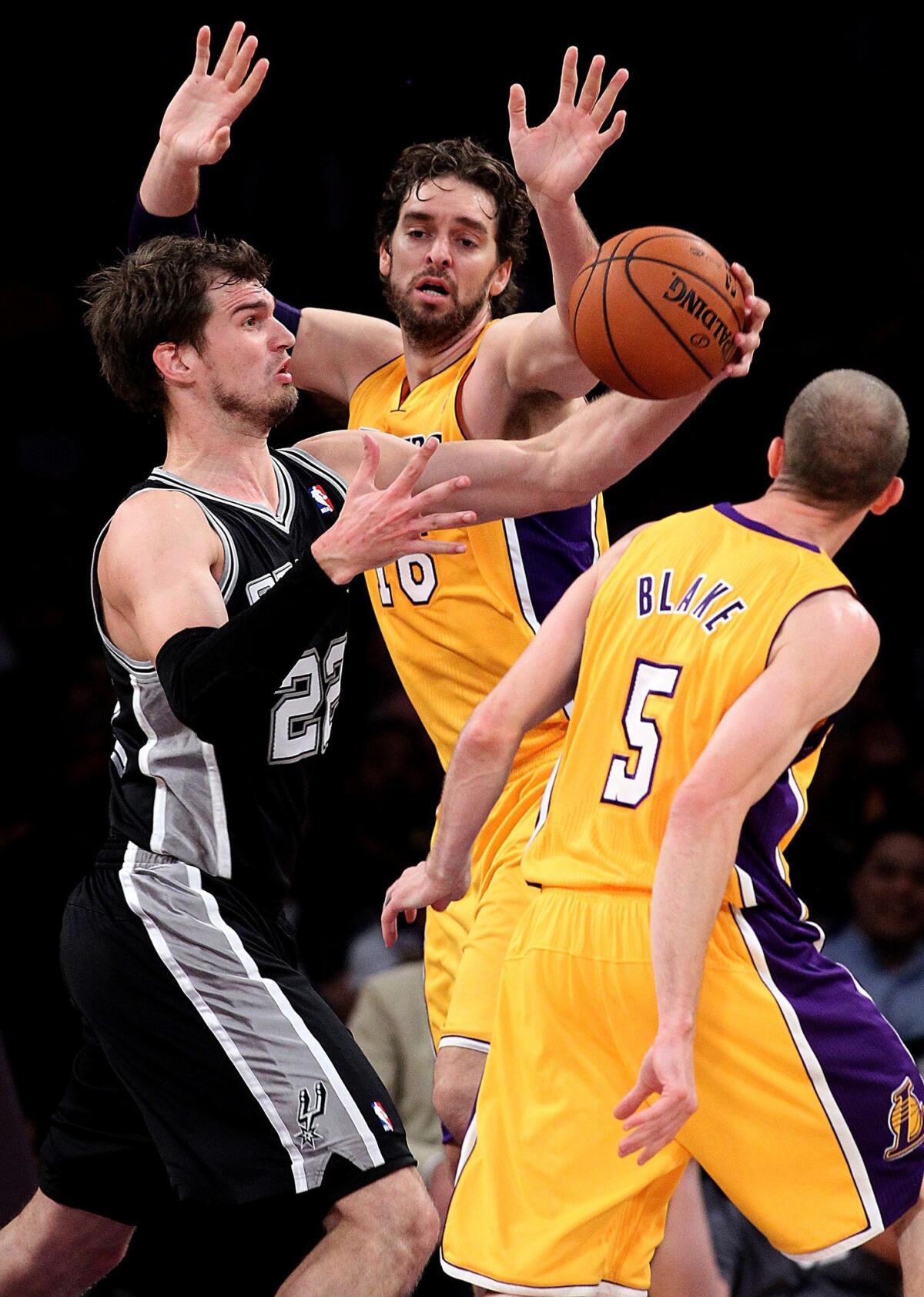 San Antonio center Tiago Splitter, left, grabs a rebound in front of Lakers forward Pau Gasol, center, and guard Steve Blake during the first half of Friday's game at Staples Center.