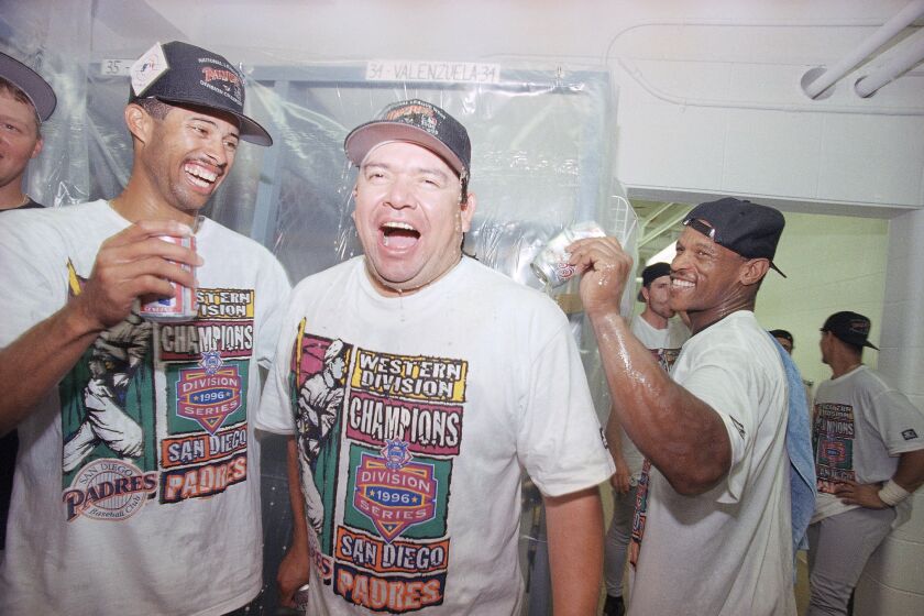 San Diego Padres’ pitcher Fernando Valenzuela, center, is doused with beer by the teammate Rickey Henderson.
