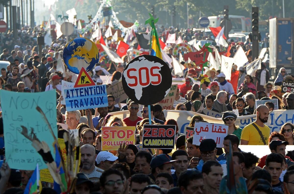 Moroccan and international demonstrators shout slogans and hold placards against pollution during a demonstration in Marrakech, Morocco, on the sidelines of the climate conference on Nov. 13, 2016.