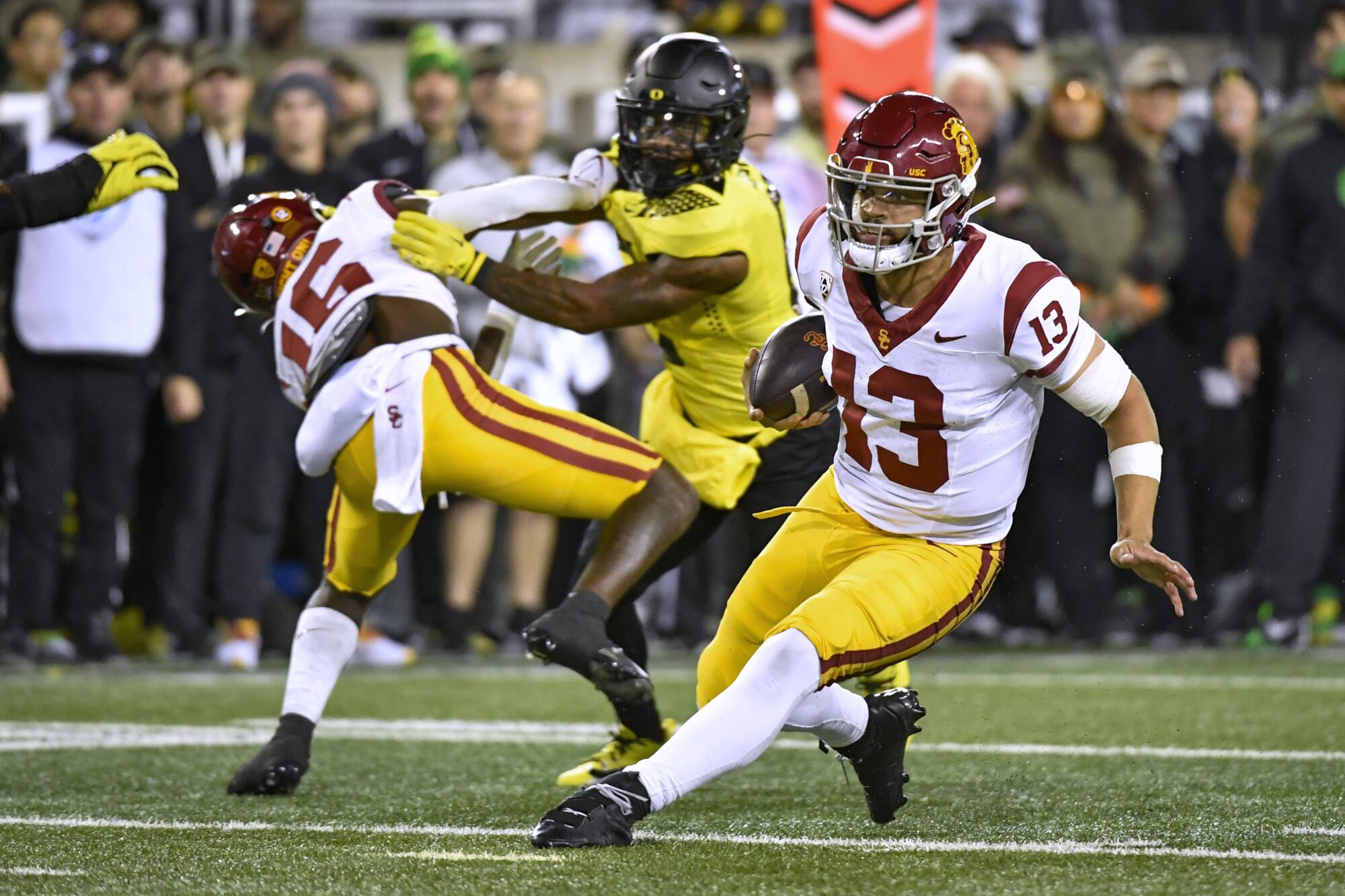 USC quarterback Caleb Williams carries the ball and scrambles for a first down against Oregon 