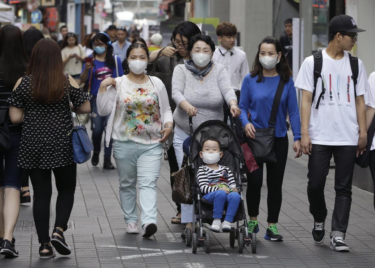Visitors to a shopping district in Seoul wear masks. Many people in the city have taken to wearing particulate-filtering masks as a precaution against Middle East respiratory syndrome.