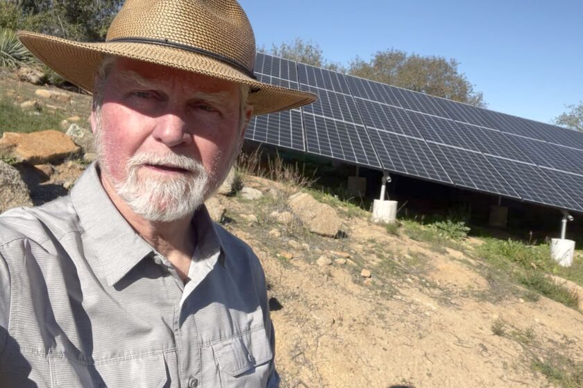 Rob Lewallen, moderator for Sustainable Ramona community forum, displays a component of his mini-microgrid at his property. 