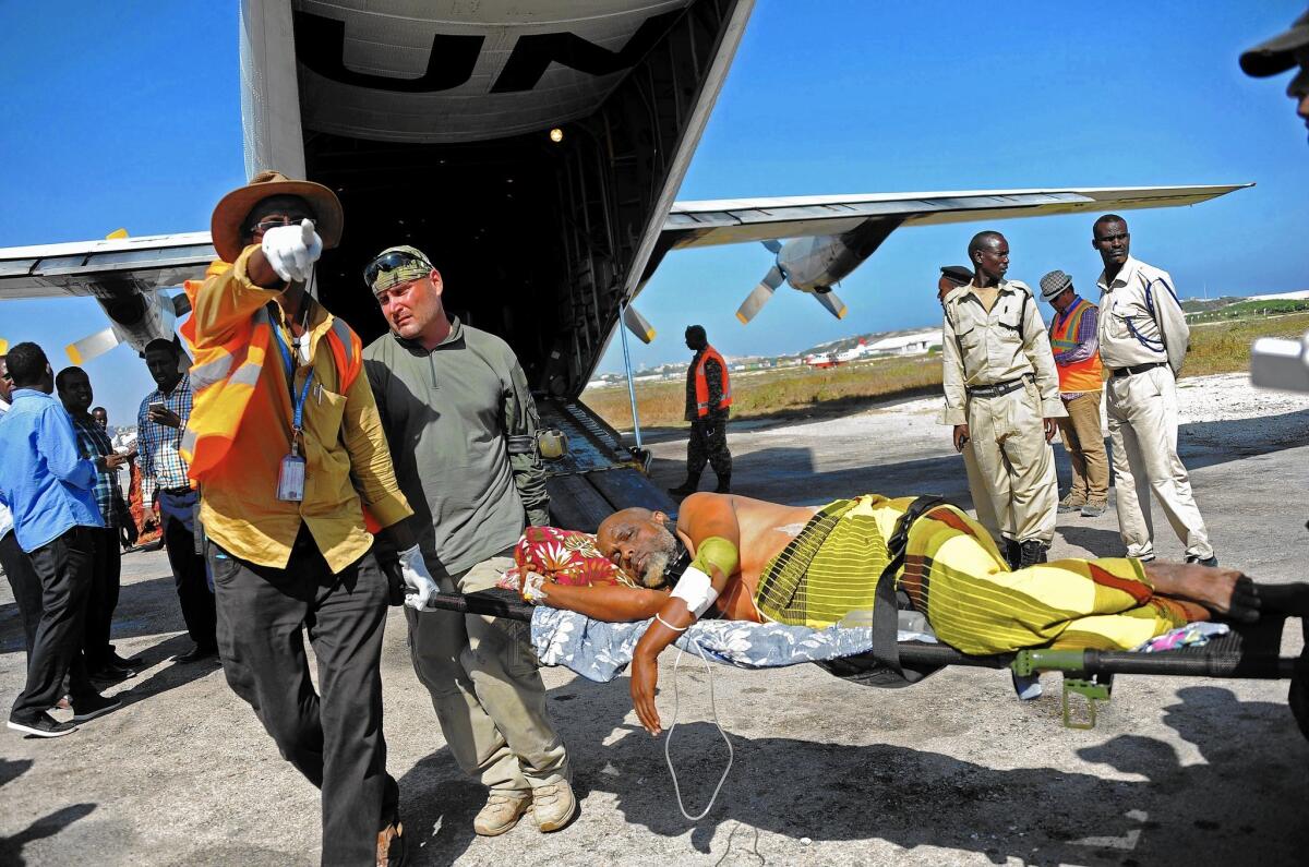 U.N. medical staff members help a wounded civilian at Mogadishu airport in Somalia after bomb attacks claimed by the Shabab last month.