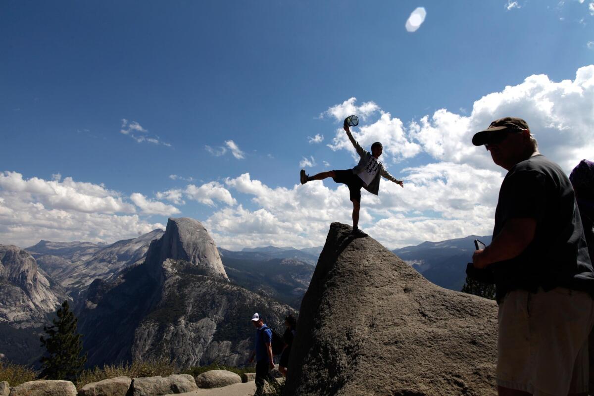 Tourists last year hammed it up for photos with Half Dome taken near the entrance to Glacier Point.